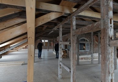 Im Dachboden sind bereits schadhafte Balken ausgewechselt und Gaupen eingebaut worden. Rechts im Hintergrund das Treppenhaus.