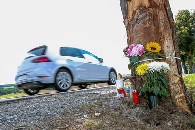 Trauernde haben Kerzen und Blumen an dem Baum hinterlassen, an dem zwei junge Männer verunglückten.