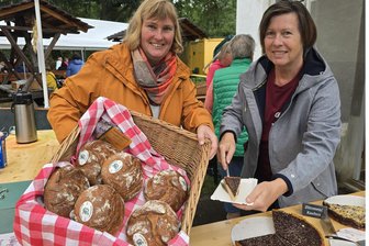 300 Jahre Gräfenmühle in Neukirchen: Darum ist das Jubiläumsbrot ein Renner - Nadja Oehler (links) und Ute Thomas brachten nicht nur das Jubiläumsbrot „300 Jahre Gräfenmühle“ der Bäckerei Dörr an die Besucher. Auch leckeren Kuchen und Kaffee hatten sie Angebot.