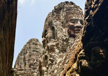 Steinerne Gesichter des Bayon-Tempels in der antiken Stadt Angkor Thom - kaum jemand lächelt zurück dieser Tage.
