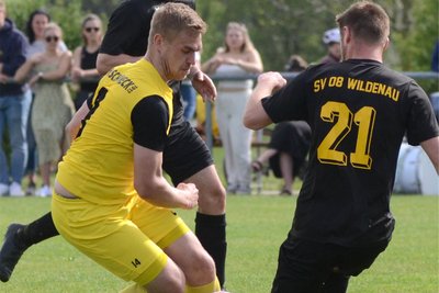 Der Schönecker Jan Luderer (in Gelb) versucht den Zweikampf gegen Wildenaus Philipp Müller zu gewinnen.