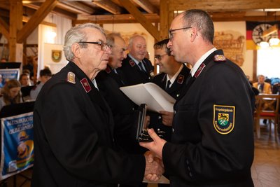Der stellvertretende Kreisbrandmeister im Mittleren Erzgebirge Kay Kretschmar (r.) zeichnet Wolfgang Blosen von der Feuerwehr Oberneuschönberg für 60 Jahre treuen Dienst aus.