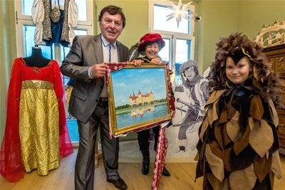 Überraschung gelungen: Die beiden Aschenbrödel-Fans Brigitte Wicklein und Rosalie Lindner (rechts) aus Ehrenfriedersdorf überreichen Schauspieler Pavel Trávníček bei seinem Besuch in Olbernhau ein Gemälde von Schloß Moritzburg. Das hatte Brigitte Wicklein zu ihrem 60. Geburtstag geschenkt bekommen.