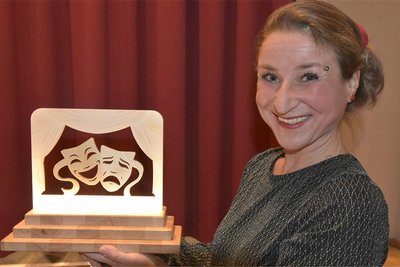 Die Moderatorin des Abends Kerstin Weinper mit dem Wanderpokal „Schönecker Oscar", der an das Theaterdorf Zwota als Ausrichter der 2. Theatertage übergeben wurde.