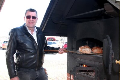 Silvio Jürgens holt frisch gebackene Brote aus dem Holzbackofen in Rothenkirchen.