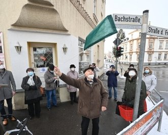 An das Straßenschild wurde eine kleine Tafel geschraubt. 