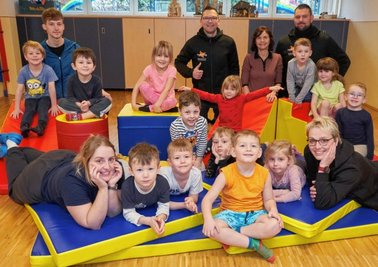 Robert Doller (Mitte hinten) liefert europaweit - und engagiert sich vor der Haustüre. Die Kita Goldene Kindersonne Reichenbach um Leiterin Steffi Hornung (hinten) freut sich über gesponserte Matten für den Kitasport. 