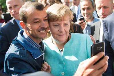 Die ehemalige Bundeskanzlerin Angela Merkel (CDU) lässt sich nach dem Besuch einer Erstaufnahmeeinrichtung für Asylbewerber für ein Selfie zusammen mit einem Flüchtling fotografieren.