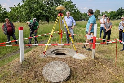 Vermessungstechniker Andreas Schubert (Mitte rechts) erläutert Regionalentwicklungsminister Thomas Schmidt (CDU) die 24-stündige Eichung des geodätischen Grundnetzes an einem Messpunkt in Meerane. 