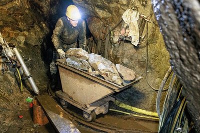 Dustin Kauz von der Bergsicherung Schneeberg schiebt den Förderwagen, der etwa 0,7 Kubikmeter des abgesprengten Gesteinsmaterials fasst, mehrfach am Tag durch den schmalen Wilhelm Morgengang. 