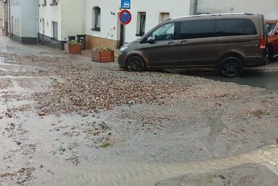 Geröll und Schlamm spülte der starke Regen in Lößnitz auf die Straße. Dort wurden Keller überflutet.
