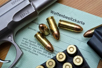 Eine Kaliber 9 mm Pistole, Patronen und ein Magazin liegen auf einer Waffenbesitzkarte:  Behörden haben mehr Rechtsextremisten mit Waffen auf dem Schirm.