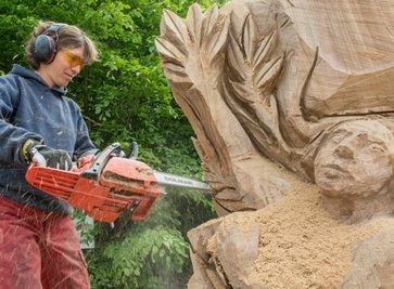 Donnerstag: Holzbildhauerin Stephanie Huber aus Deutschland arbeitet an der Daphne, die in der griechischen Mythologie eine Jägerin war. Huber hat den Körper grob geformt und der Figur schon ein Gesicht gegeben. Während sie nun am Lorbeerbaum sägt, arbeitet ihre Teamkollegin Edith Plazotta an Apollon, der unsterblich in Daphne verliebt ist. .
