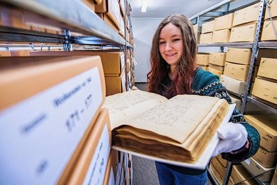 Michelle Mittag, Mitarbeiterin im Kreisarchiv Jahnsdorf, kennt sich mit alten Akten und Dokumenten aus. Hier zeigt sie einen Bucheinband mit Rechtsdokumenten und Ratsprotokollen aus Wolkenstein. 