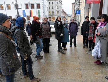 Ute Schnabel (r.) vom Zeitzeugen-Verein vermittelte bei ihrer Stolperstein-Führung vom Obermarkt (im Bild) über die Burg- und Thielestraße zur Kreuzgasse Wissenswertes über jüdisches Leben in Freiberg. Die kleinen Tafeln im Boden erinnern an Menschen, die in der NS-Zeit ermordet oder in den Suizid getrieben wurden. 