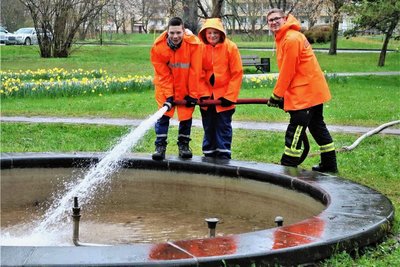 Beim Frühjahrsputz in Flöha wurde durch Elias Richter (v.l.), Fabio Schröder (beide Jugendfeuerwehr) und Martin Kirschen von der Feuerwehr auch der Brunnen im Baumwollpark mit Wasser gefüllt. 