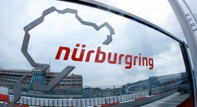 Mehr Schein als Sein. Blick durch eine Glasscheibe mit dem Logo an der Zufahrt zur Rennstrecke Nürburgring.