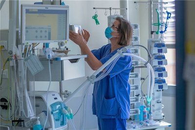 Eine Krankenschwester prüft ein Beatmungsgerät in einem Zimmer einer Intensivstation.