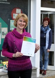 Die Vereinsvorsitzende Jana Weber (vorn) und die Stadtteilmanagerin Sabine Resche zeigen die Siegerurkunde des Ideenwettbewerbs.