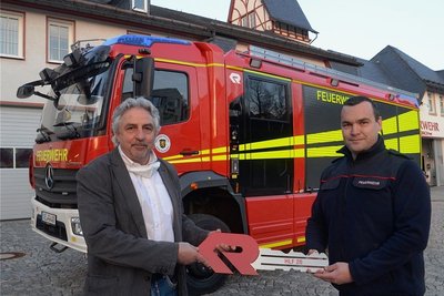Oberbürgermeister Manfred Eckert übergibt den symbolischen Schlüssel für das neue Fahrzeug an Wehrleiter Nico Voigtländer (rechts).