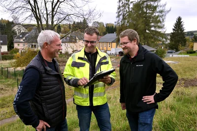 Jens Brendel, Präsident des Erzgebirgischen Heimatvereins (v. l.), Bauleiter Tilo Ullrich und Bauamtsleiter Thomas Illmann beim offiziellen Baustart für den Multifunktionsplatz am Schleifenweg in Oelsnitz.