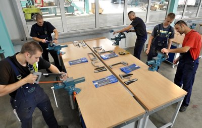 Lehrausbilder Torsten Gruber (rechts) zeigt den Auszubildenden Marcel Otto, Kevin Scharm, Lukas Heimann und Mathias Ficker (von links) im neuen Ausbildungszentrum, wie ein Werkstück richtig bearbeitet wird.
