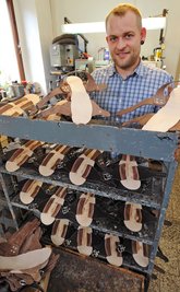Der Schuhmacher Eike Röhner präsentiert in Glauchau die von ihm in Handarbeit gefertigten Jesuslatschen. 