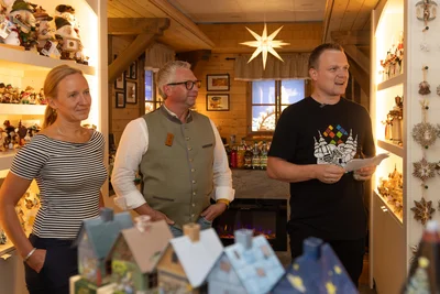 Sabine Schulze-Schwarz (l.) und Daniel Schalling (r.) von der Wirtschaftsförderung beim Abschied in Zwönitz – hier mit Gastgeber Jens Kriegel im Zwönitzer Geschäft Erzberger.