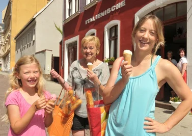 Ein kühles Eis nach dem Einkauf gönnten sich am Montag Silke Gloaguen (r.) mit Tochter Emma aus Freiberg und Oma Helga Schröck aus Stuttgart bei Ines Neumann (h. r. ) in der Italienischen Eisdiele.