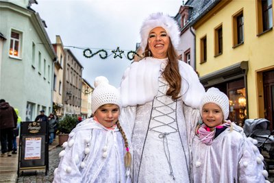 Jana Reiche läuft als Eiskönigin mit zwei Schneeflöckchen durch die Burgstädter Innenstadt.