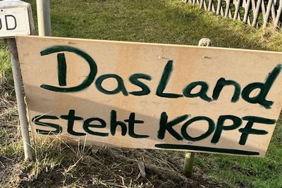 Ein Zusatzschild gibt einen Fingerzeig auf die Urheber der Proteste.