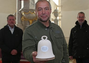 Pfarrer Michael Tetzner (hinten links), Ideengeber und Pfarrer i. R. Friedemann Müller (rechts) sowie Michael Thierfelder hoffen darauf, dass sie das benötigte Geld für die Glocken der Niederzwönitzer St. Johannis-Kirche schnell zusammenbekommen. 
