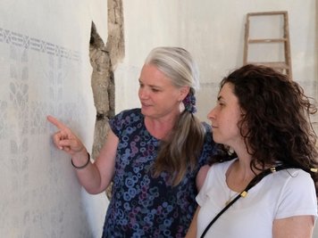Sina Lorbeer-Klausnitz und Nadine Holesch von der Museumsleitung begutachten die alte Wandbemalung im Ex-Bürgermeisterzimmer. 