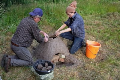 Nadine Holesch mit Thomas Petzoldt beim Nachbau eines Rennofens zur Verhüttung von Raseneisenerz. 