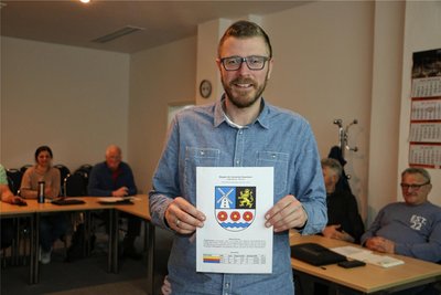 Bürgermeister Michael Frisch zeigt das zukünftige Wappen der Gemeinde Rosenbach.