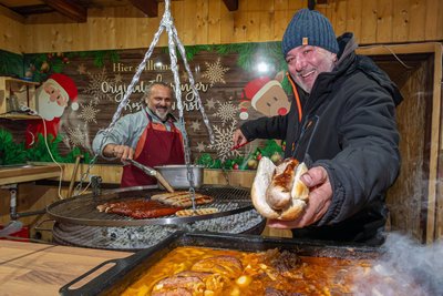 Ronny Heitmann (r.) und Minas Makris bieten auf dem Marienberger Weihnachtsmarkt unter anderem Thüringer Rostbratwurst an.