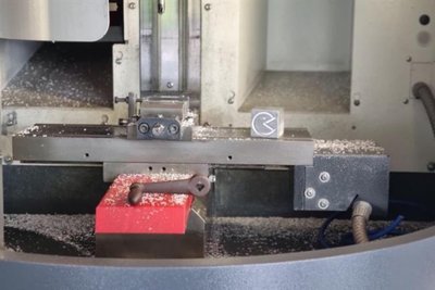 Mit der CNC-Fräse wurde ein kleines Pacman-Gesicht auf dem Metallwürfel verewigt.