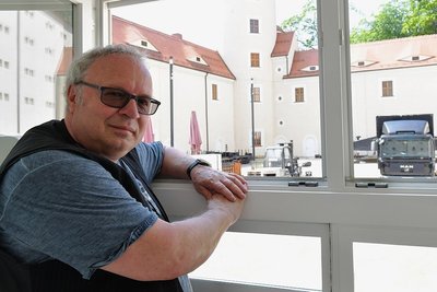 Thomas Erler schaut aus dem Filmprojektfenster zu, wie im Schlosshof Leinwand aufgebaut wird.