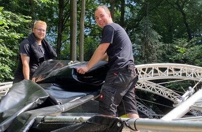 Leon Franke (l.) und Moritz Rotter am Montag beim Aufbau der Waldbühne in Börnichen. 