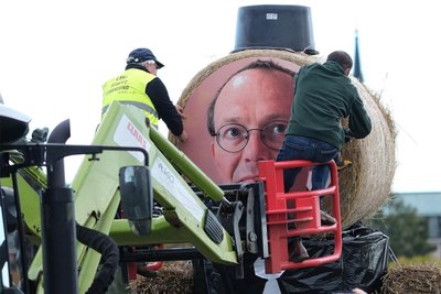 Bauernproteste in Dresden: Landwirte befestigen ein Porträt von Sachsens Landwirtschaftsminister Wolfram Günther (Grüne) an einer Strohfigur. Günther ist derzeit ihr „rotes Tuch“.