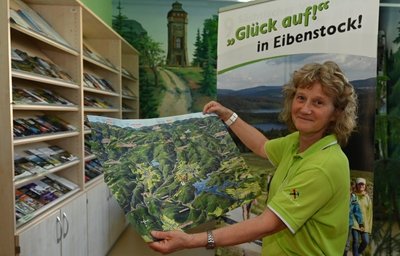 Karin Seidel vom Team des Tourist-Service-Centers in Eibenstock zeigt die Panorama-Faltkarte, die dem neuen Wanderführer beiliegt. 