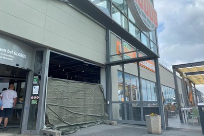 Nach dem Einbruch hatten Globus-Mitarbeiter die zerstörte Fassade notdürftig mit einem Bauzaun und Plastefolie gesichert.