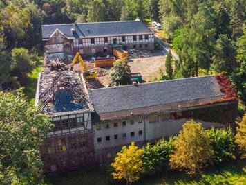 Blick aus der Luft: Gut zu erkennen ist der bei einem Brand schwer beschädigte Dachstuhl des Gebäudes. 