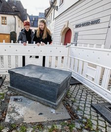 Die Buchbank aus Theumaer Naturstein wurde gewaltsam von ihrem Sockel geschoben. Die Galerie-Mitarbeiterinnen Luca Wunderlich (links) und Sarah Kühnel begutachten den Schaden. 
