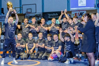 Aues Chefcoach Björn Schöniger reißt den Pokal in die Höhe: Wie voriges Jahr feierten die Ringer des FC Erzgebirge gleich zwei Titel und diesmal auch einen Aufstieg. Aber es gab auch einen bewegenden Abschied.