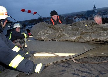 
              <p class="artikelinhalt">In Frankenberg deckte der Sturm teilweise das Dach des Krankenhauses ab. Feuerwehrleute aus Frankenberg und die Firma Dachisolierung Flöha versuchten am Samstagabend, eine Plane anzubringen. </p>
            