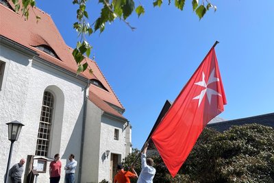 Die junge Pilgergruppe, die jedes Jahr von auswärts drei Tage nach Großschirma pilgert, stellte 2023 die Johanniter-Fahne vor der Kirche in Großschirma auf. Dieses Mal startete die Gruppe in Meißen.
