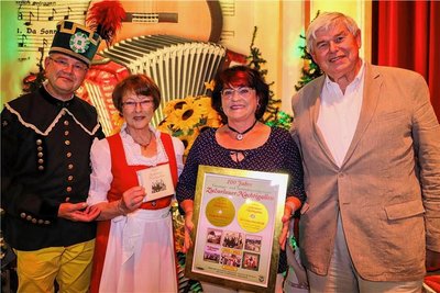 Als Überraschung gab es für die beiden "Nachtigallen" Sigrid Wigand (links) und Gudrun Kotsch von Volkmar Andrä (rechts) eine Auszeichnung zum 100. Geburtstag des Ensembles; links Moderator Steffen Kindt. 