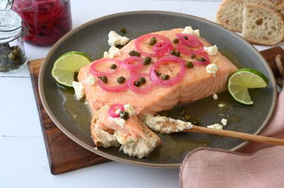 Die Marinade zum gegrillten Lachs sorgt für ein buttrig-süßes Aroma und bildet einen wunderbaren Kontrast zu den sauer eingelegten Zwiebeln und den salzigen Kapern. 