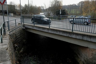 Die Brücke über den Raumbach in Höhe der Bergstraße soll durch einen Neubau ersetzt werden. Die Stützwand auf der Straßenseite wird instand gesetzt. Leitungen sind neu zu verlegen.